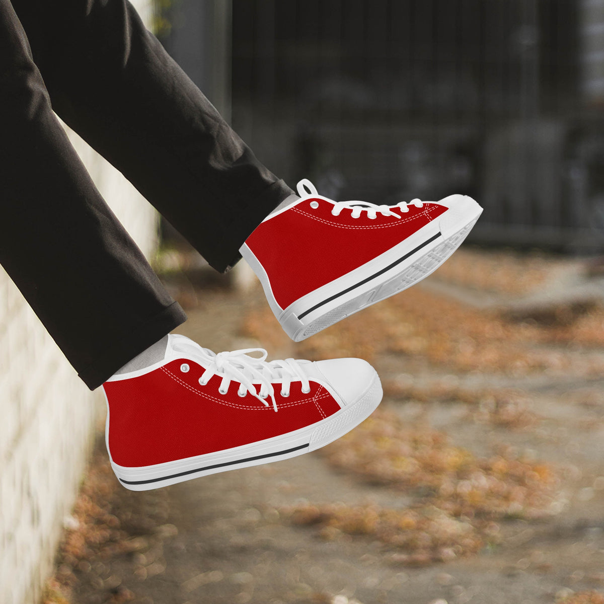 Crake High Top Red Sneaker with white trim worn with dark trousers outdoors