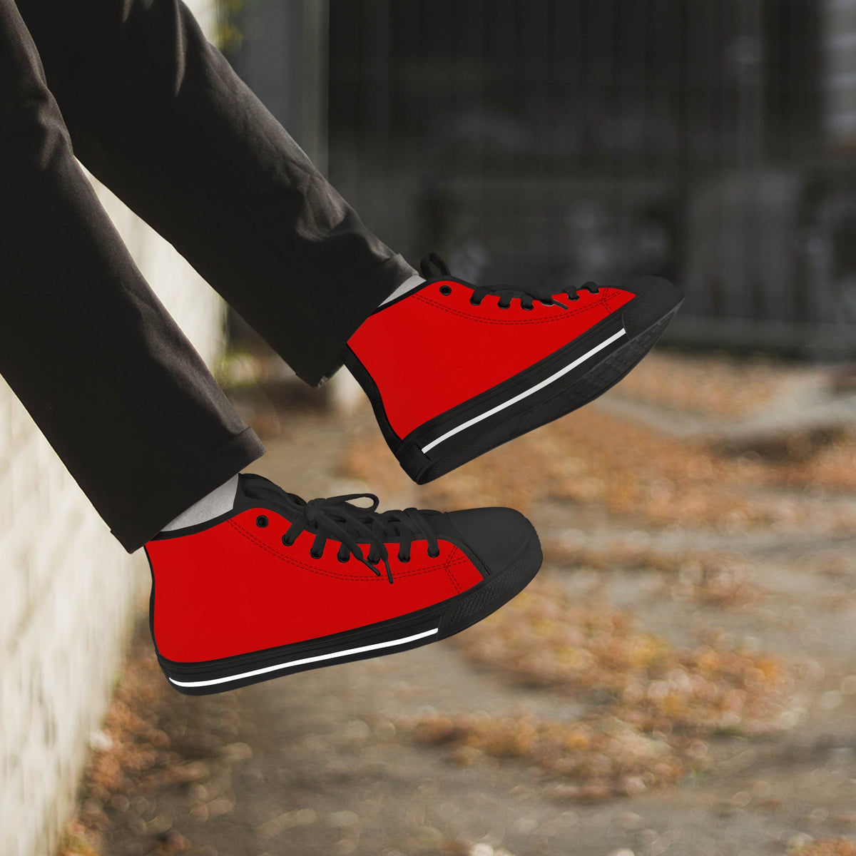 Crake High Top Red Sneaker with black trim worn with dark trousers outdoors